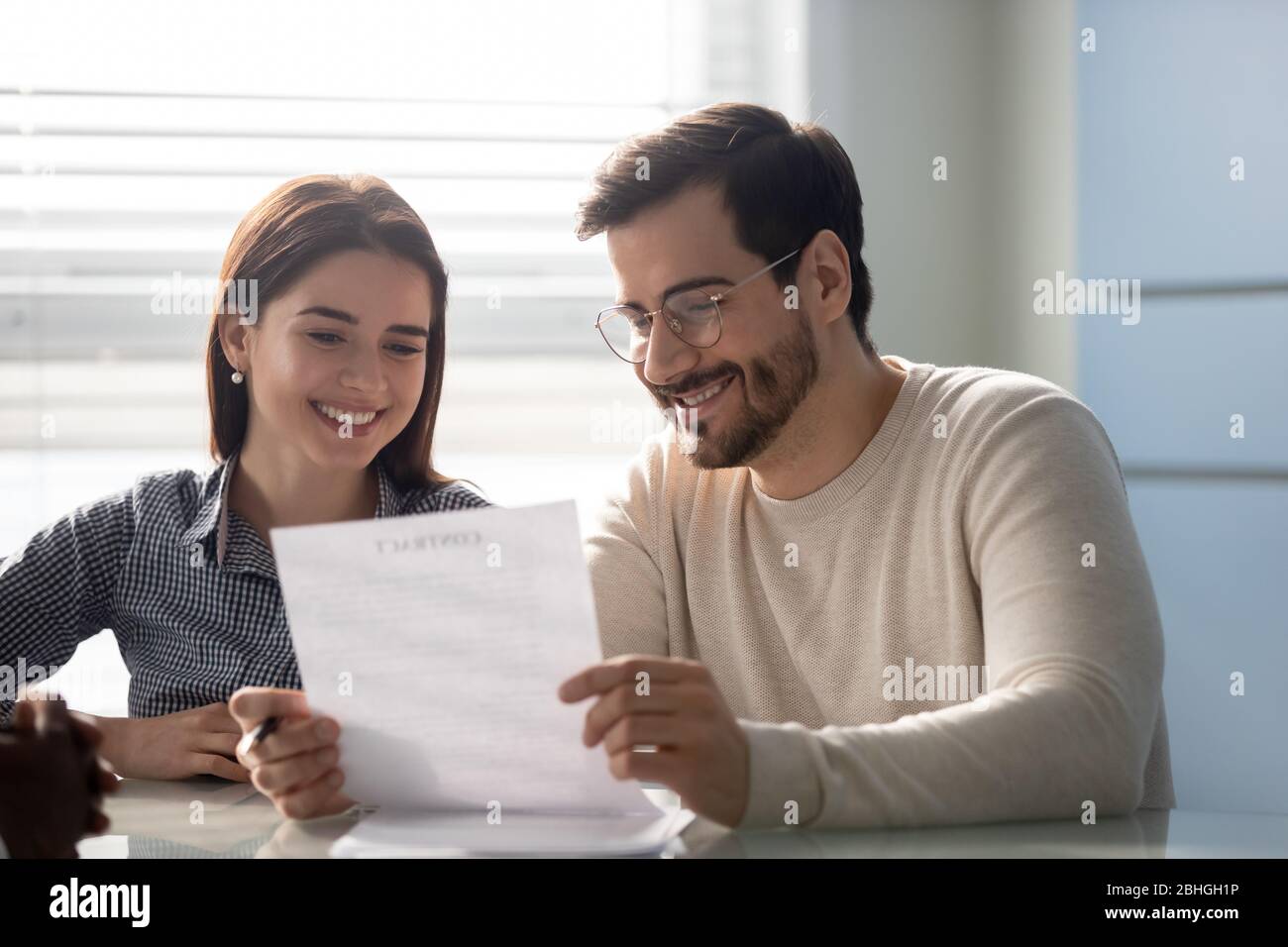 Jeune couple, homme et femme à succès lisant le document d'affaires. Banque D'Images