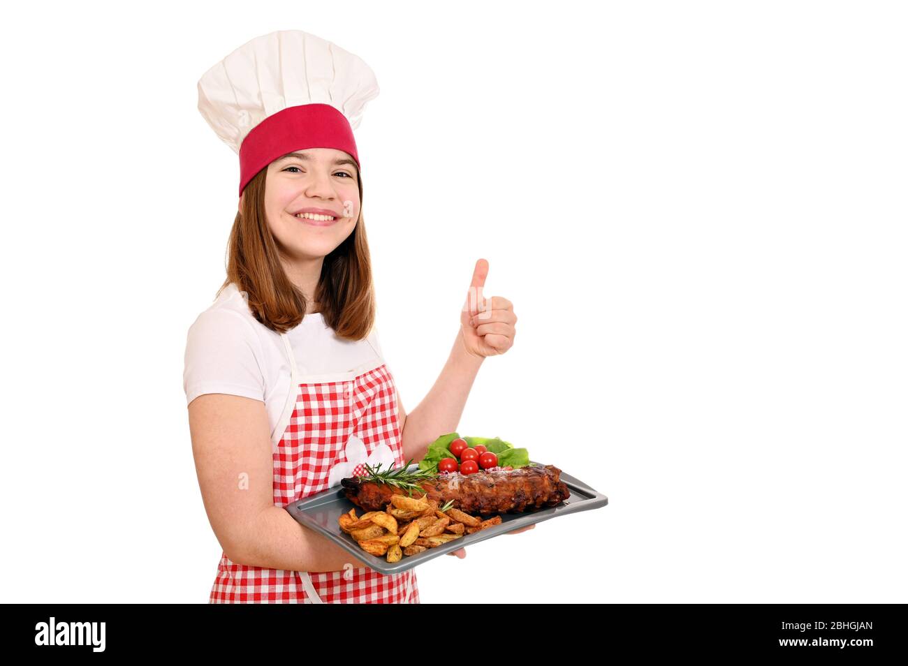 happy girl cuisinier avec côtes de porc à la plaque et pouce vers le haut Banque D'Images