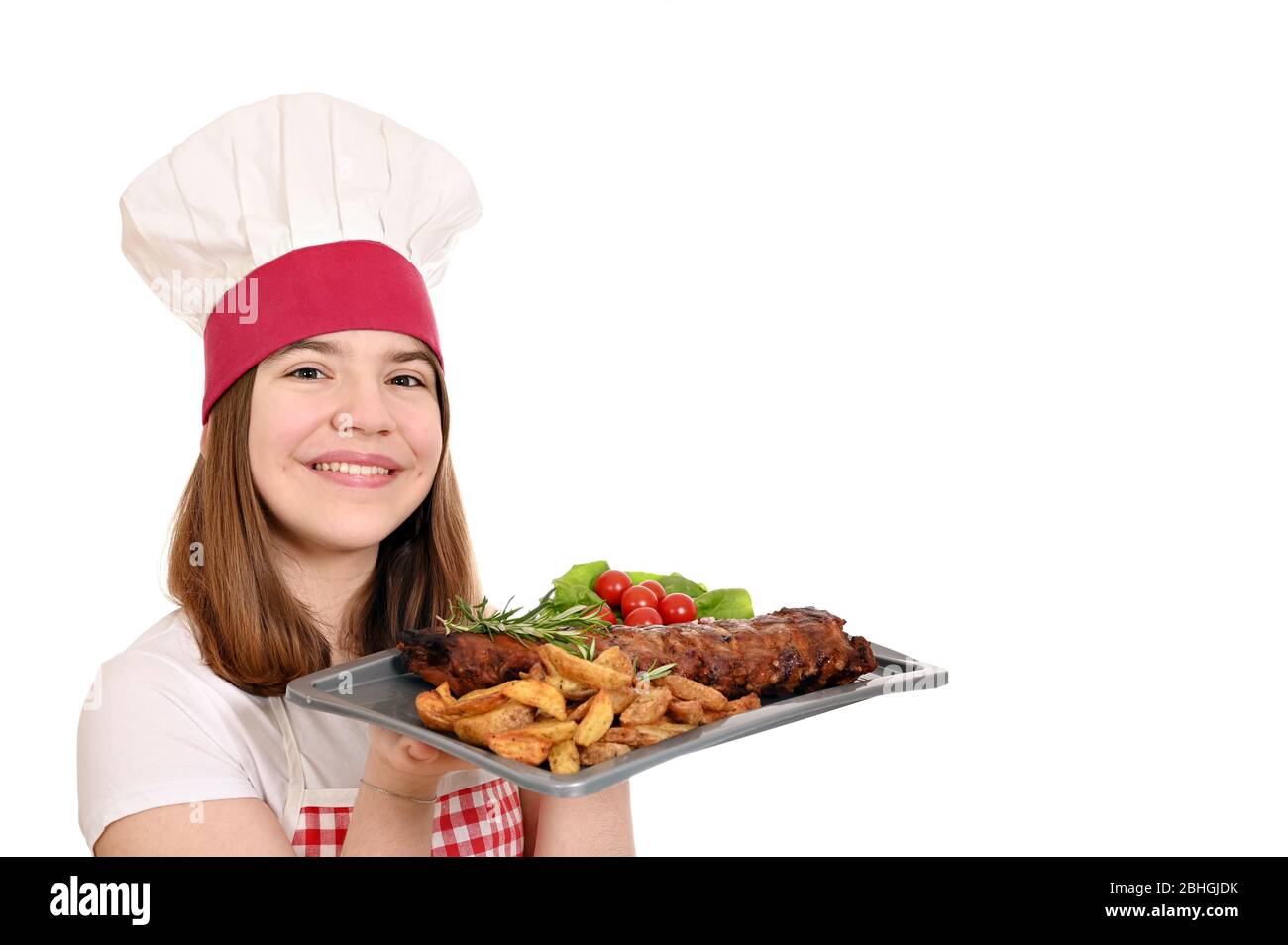 happy girl cuisinier avec des côtes de porc de rechange à la plaque Banque D'Images