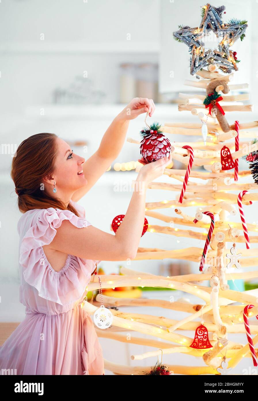 jeune femme décoration extraordinaire, eco sympathique arbre de noël fait de branches, vacances d'hiver Banque D'Images