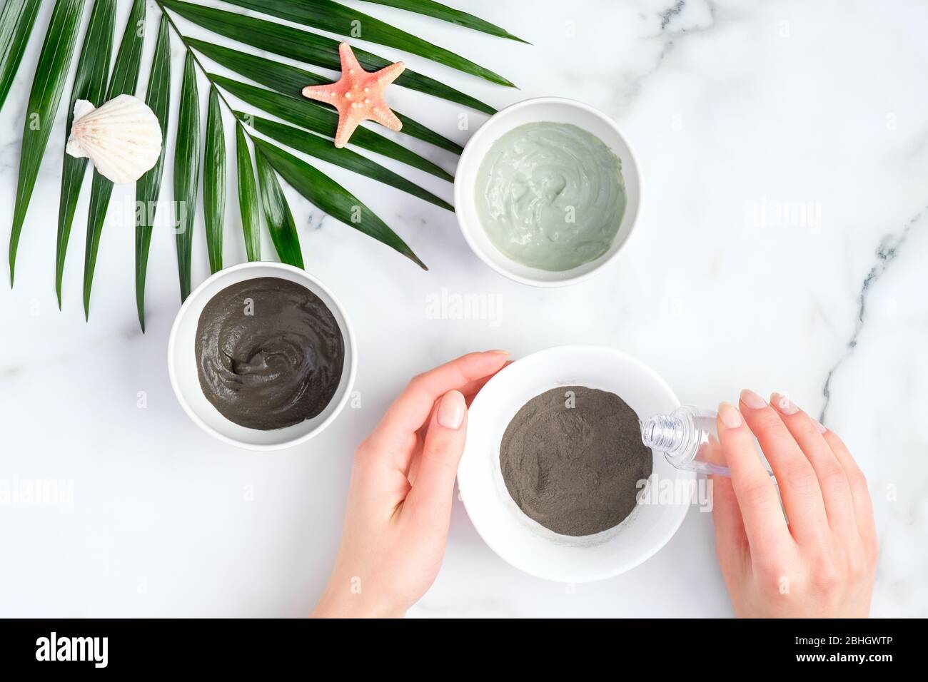 Mains féminines préparant le masque d'argile de visage, vue de dessus. SPA cosmétiques biologiques naturels, traitement du visage, concept de soins de la peau Banque D'Images