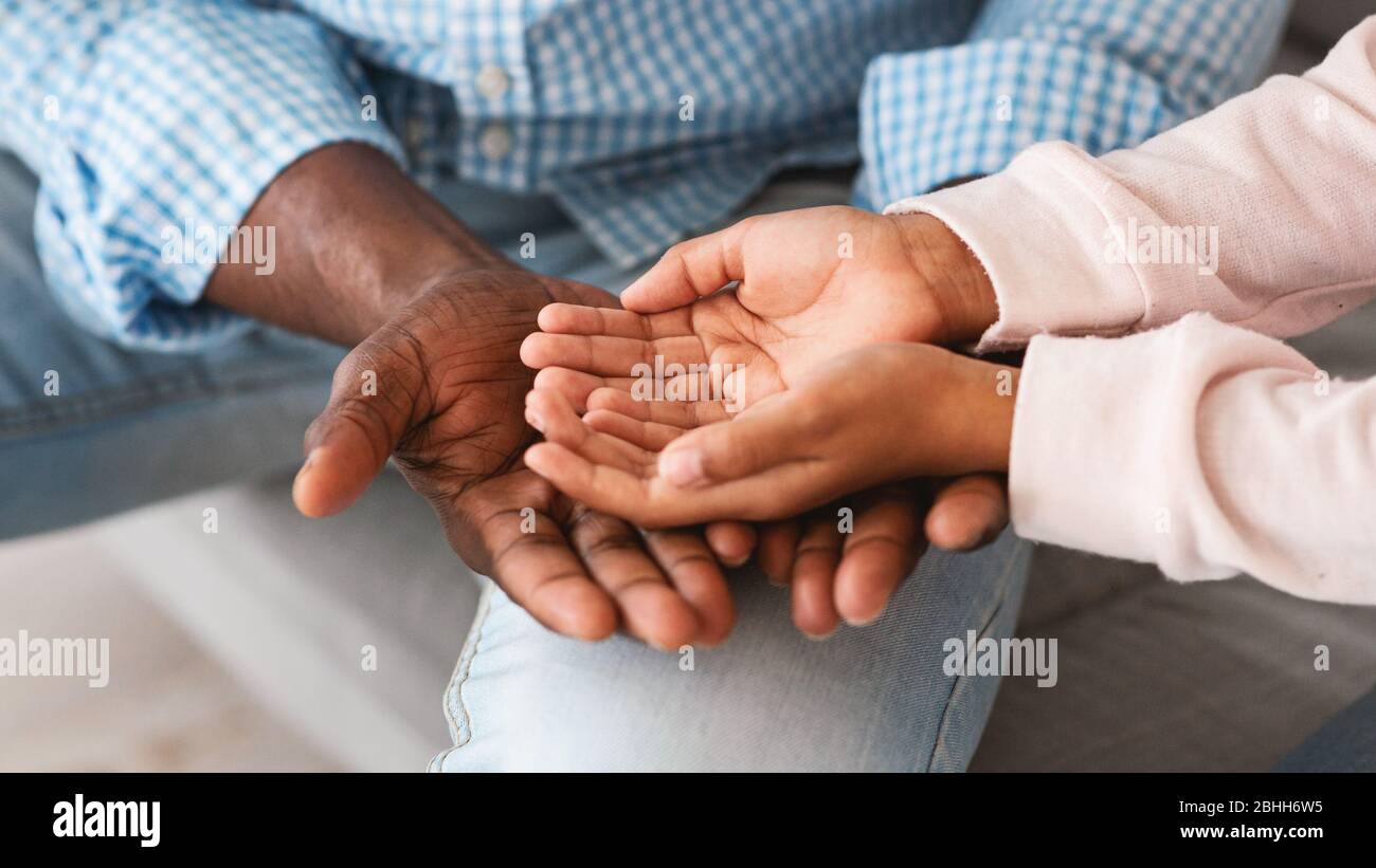 Temps de liaison familiale. Gros plan d'un grand-père et d'un petit-enfant non reconnaissables tenant les mains ensemble. Panorama Banque D'Images