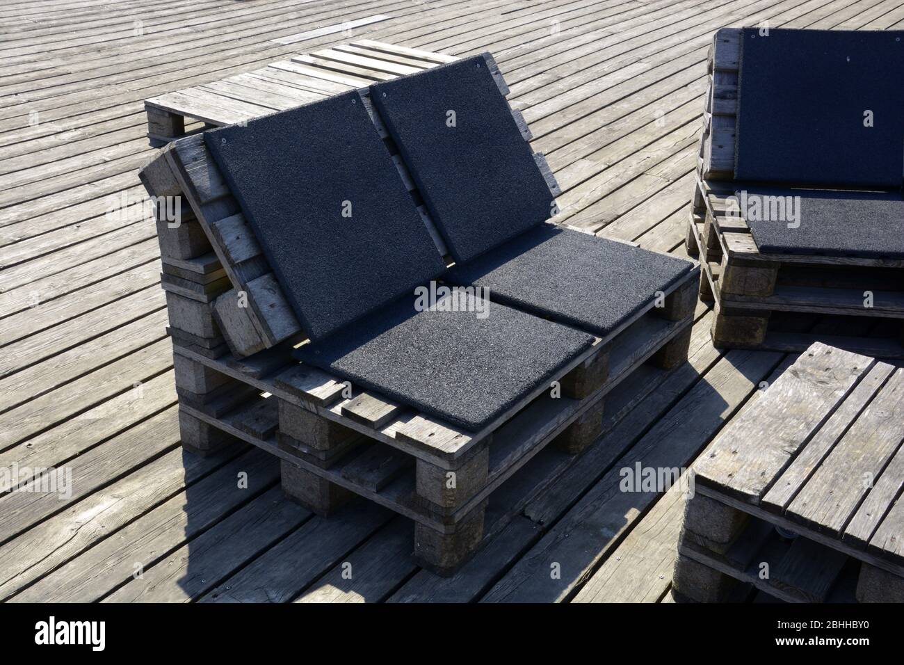 élégants bancs de jardin ou de terrasse fabriqués à partir de palettes de stockage en bois anciennes en été Banque D'Images