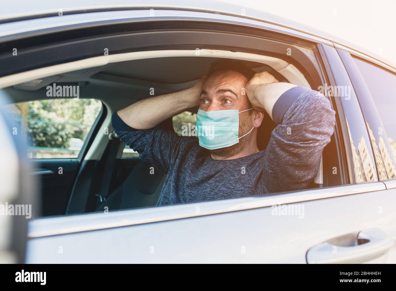 L'homme portant un masque de protection pour éviter l'infection du virus et les désouses polluées à l'intérieur de sa voiture. Soins de santé, coronavirus, grippe Banque D'Images