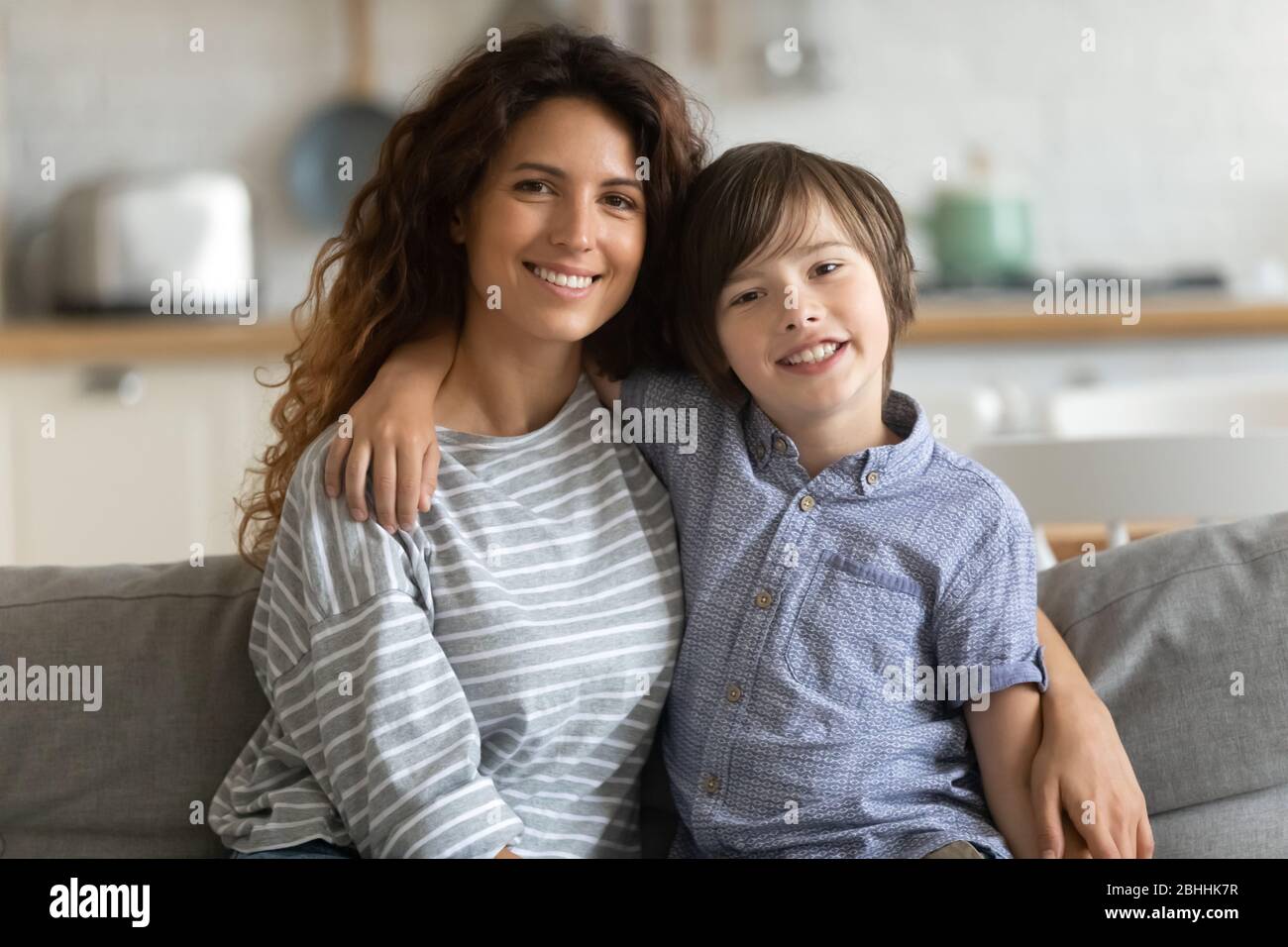 Jolie mère simple posant pour la photo de famille avec son fils. Banque D'Images