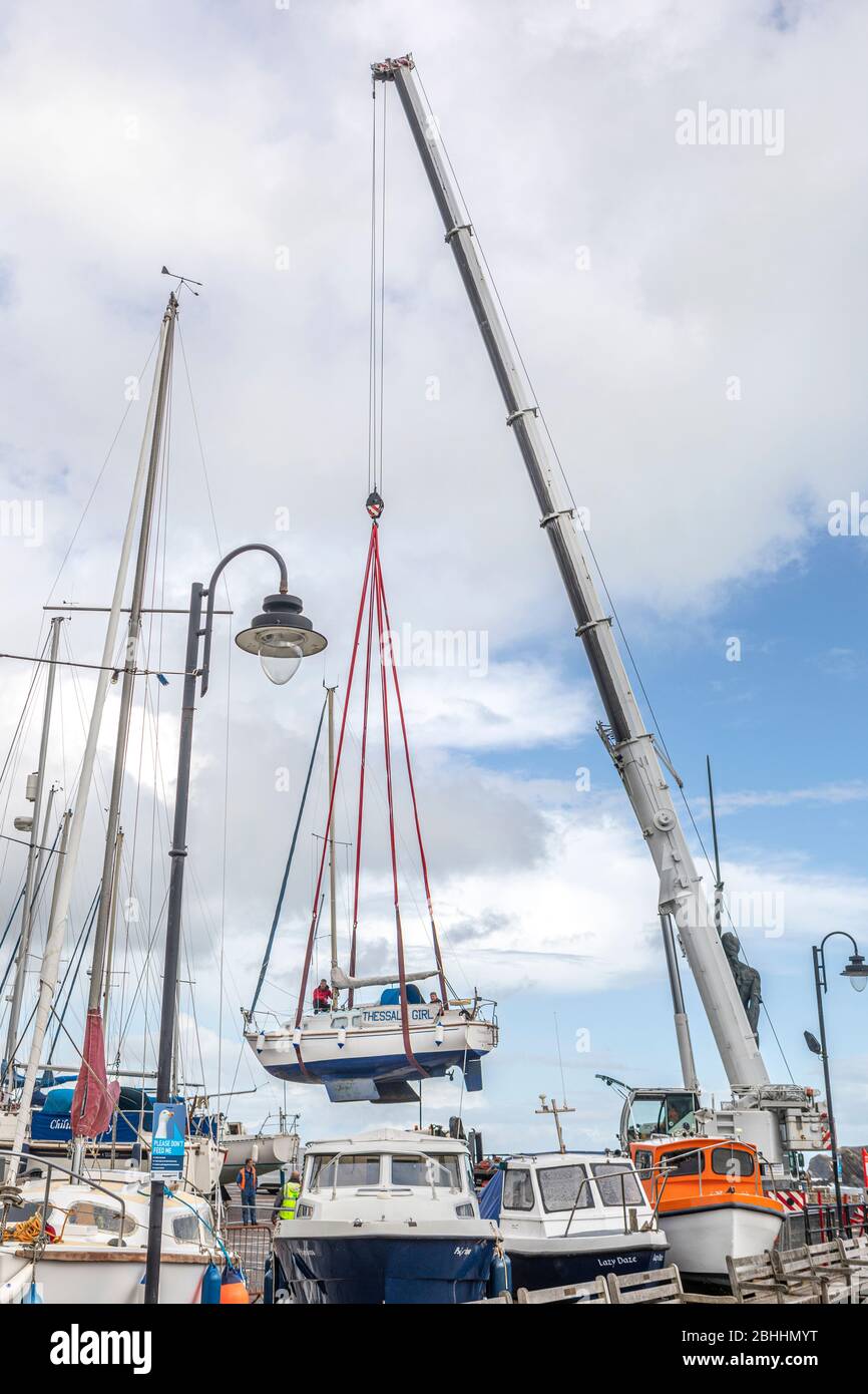 Une grue hante un petit bateau dans un chantier naval. Banque D'Images