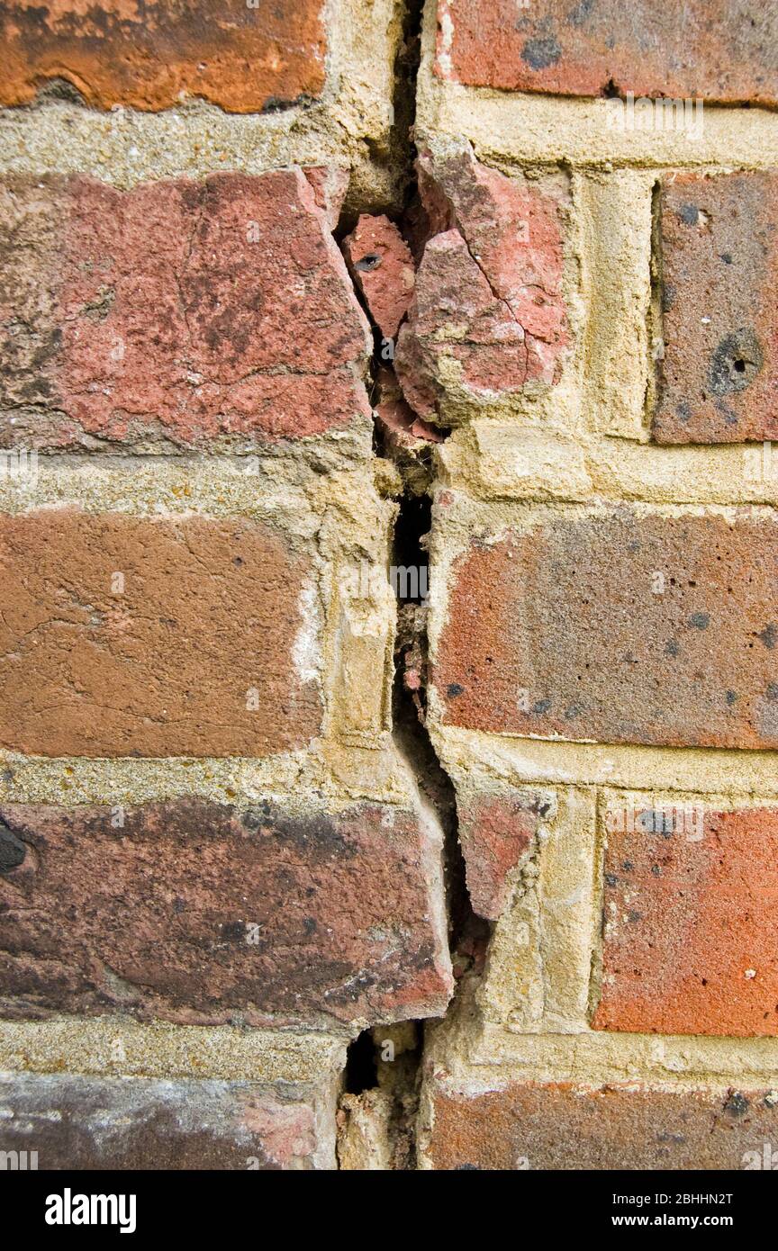 Une fissure verticale dans un mur de briques. Banque D'Images