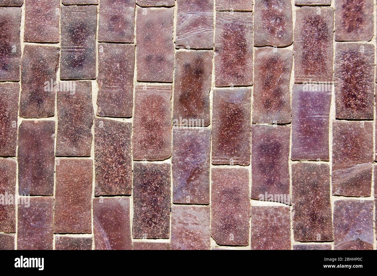 Gros plan sur un mur recouvert de carreaux de céramique de mosaïque violette. Banque D'Images