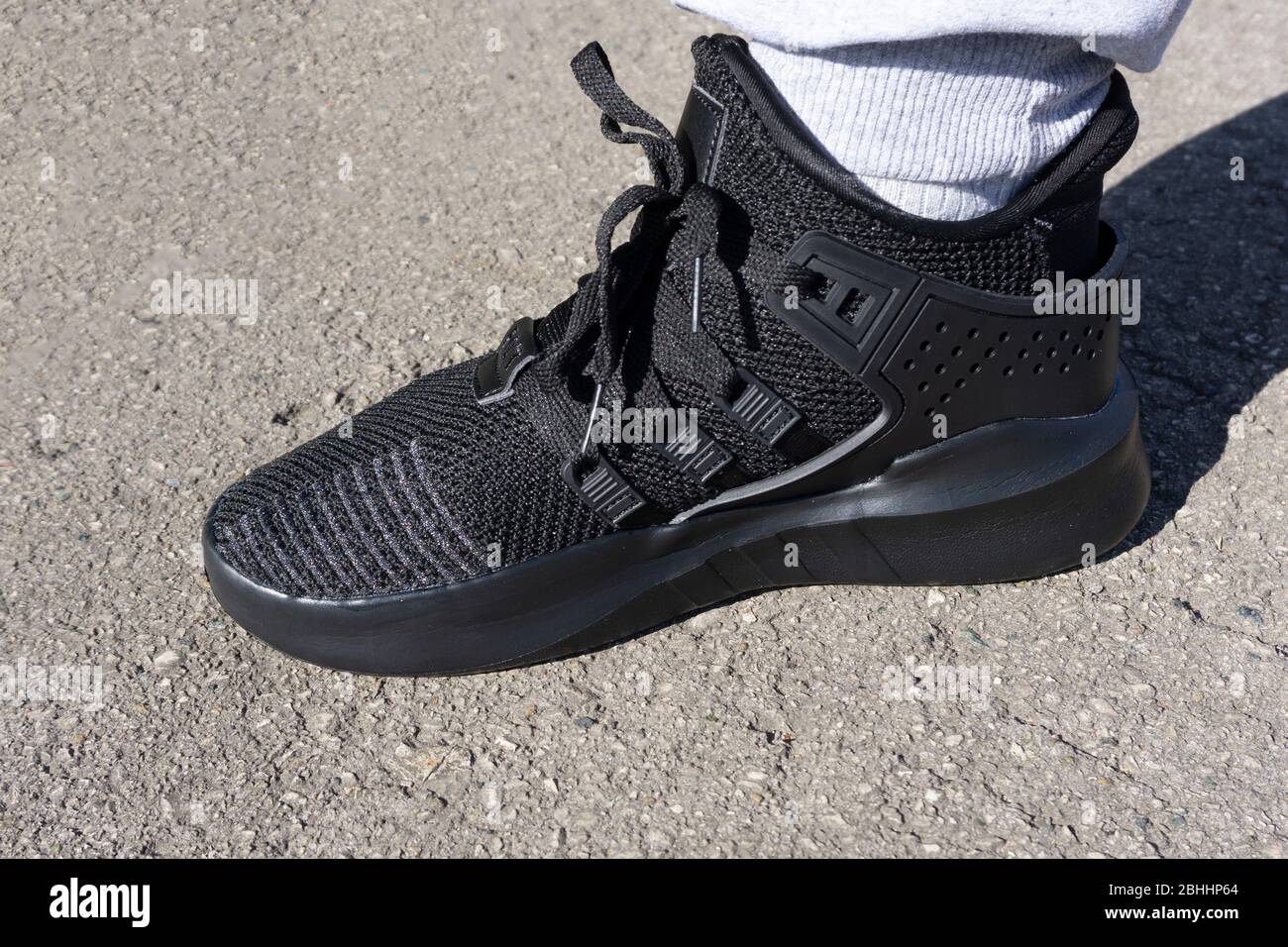chaussures de course à pied sombres sur l'asphalte au soleil . Banque D'Images