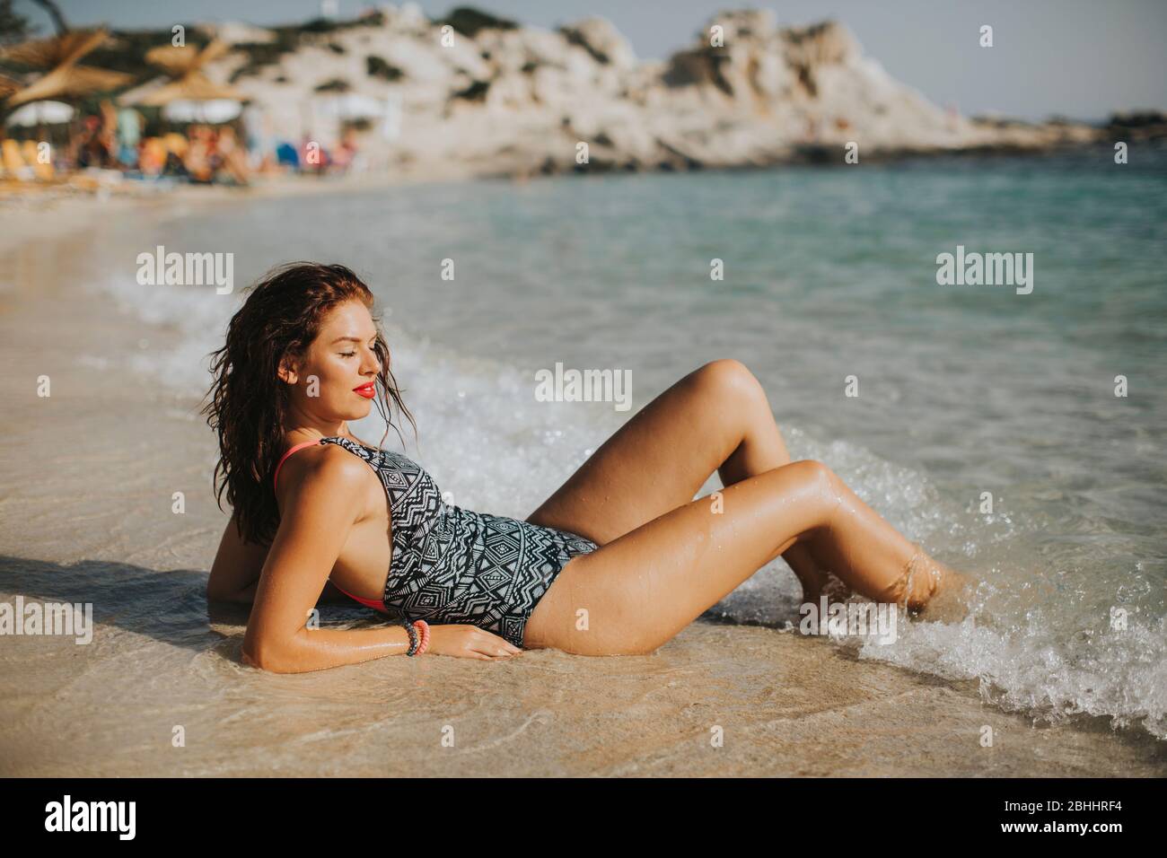 Jolie jeune femme vêtue de bikini relaxant sur le bord de mer en vacances d'été Banque D'Images