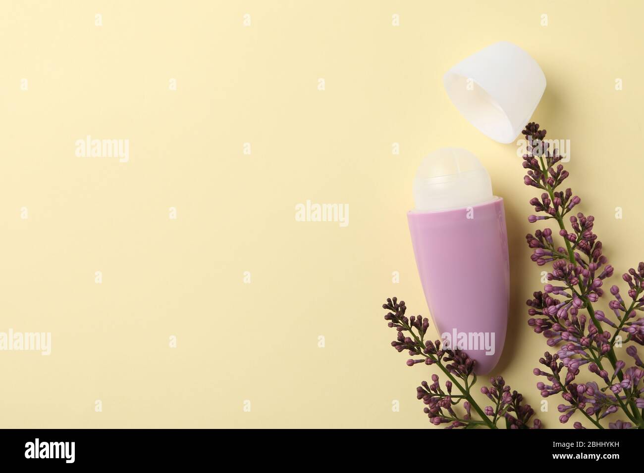 Désodorisants anti-transpiration pour le corps roulés et lilas sur fond beige, espace pour le texte Banque D'Images