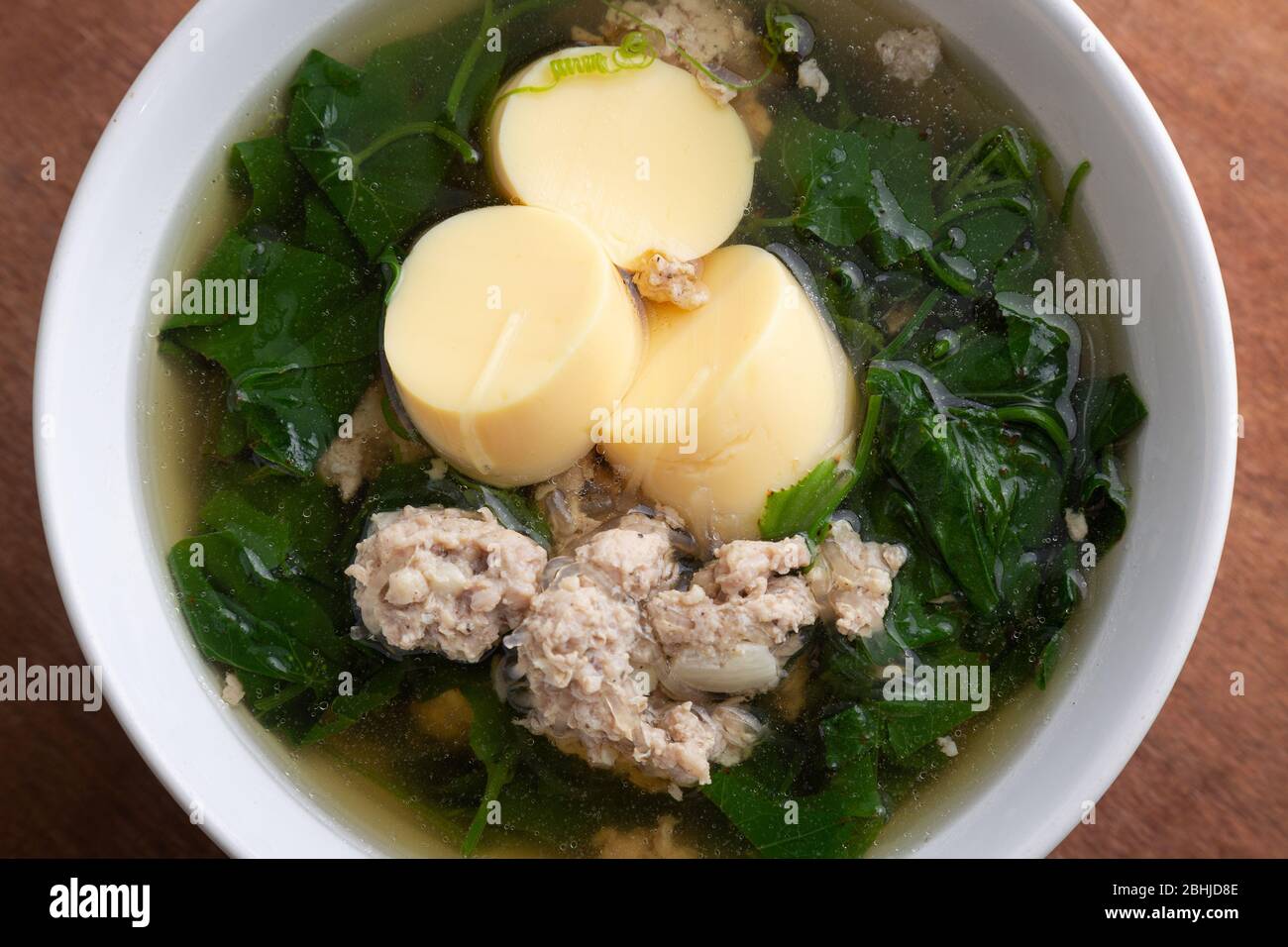 Soupe de porc et tofu hachée bouillies avec gourd dans un bol blanc sur table en bois, cuisine thaïlandaise, nourriture saine. Banque D'Images Soupe de porc et tofu hachée bouillies avec gourd dans un bol blanc sur table en bois, cuisine thaïlandaise, nourriture saine. Banque D'Images