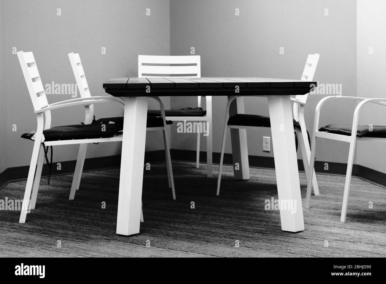 Photo en noir et blanc d'une table et de chaises en aluminium blanc qui se doublage comme salle de réunion de bureau à l'intérieur. Jusqu'à ce que le temps soit bon. Banque D'Images