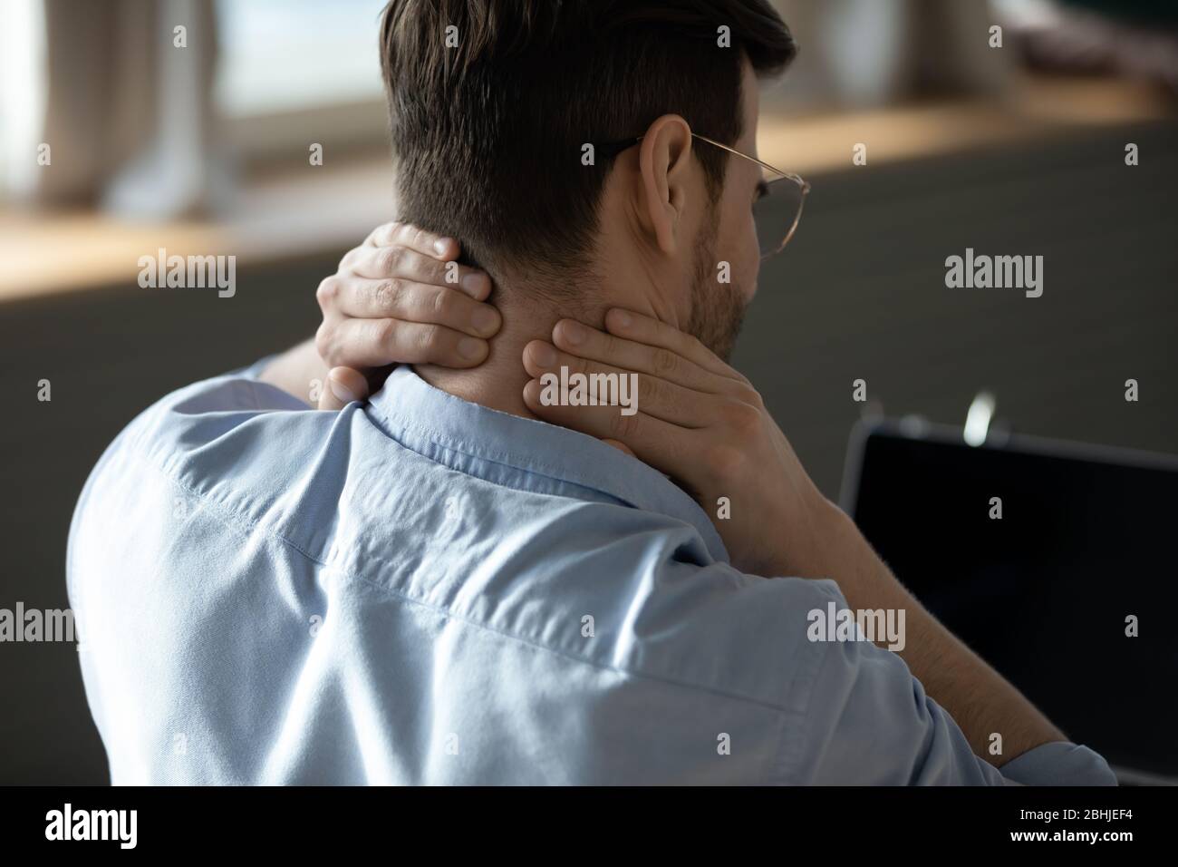 Gros plan jeune homme fatigué massant des muscles raides du cou Banque D'Images