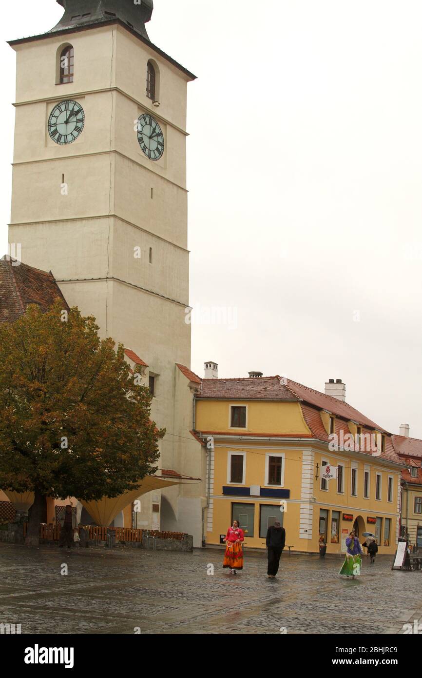Tsiganes dans les rues de Sibiu, Roumanie. La Tour du Conseil (Turnul Sfatului) sur la Grande place. Banque D'Images