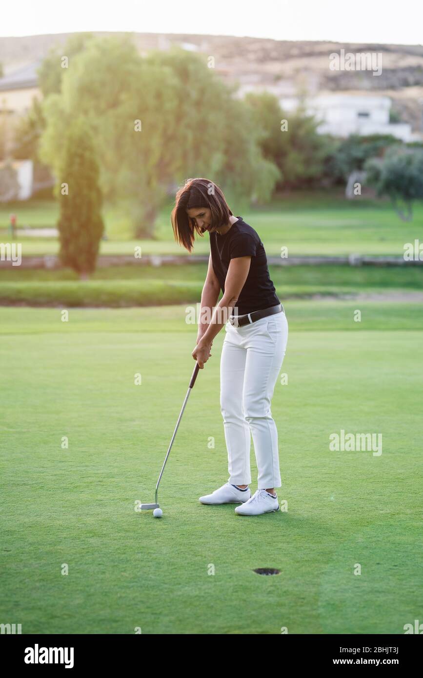 Femme jouant au golf sur un beau parcours de golf Banque D'Images