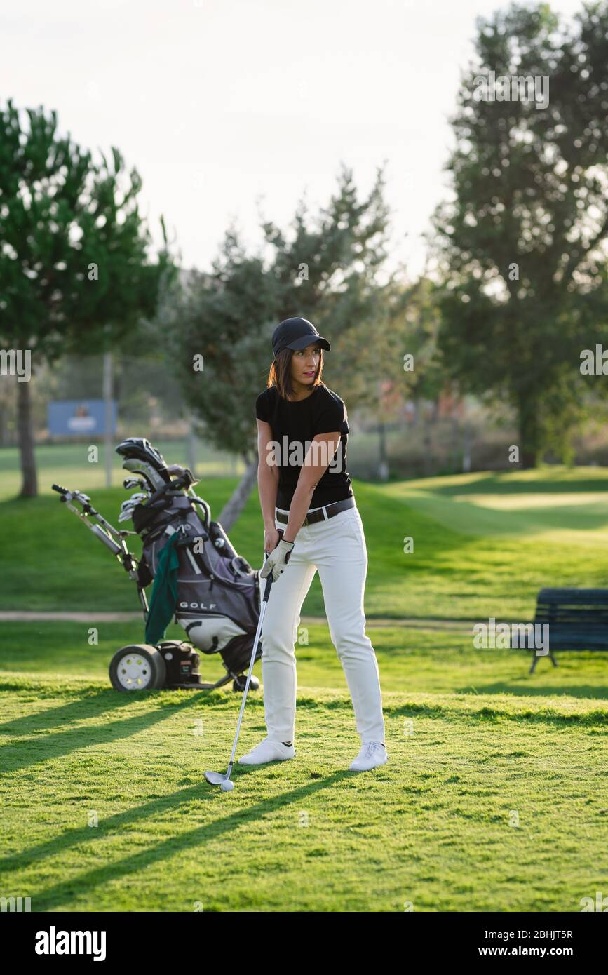 Femme jouant au golf sur un beau parcours de golf Banque D'Images