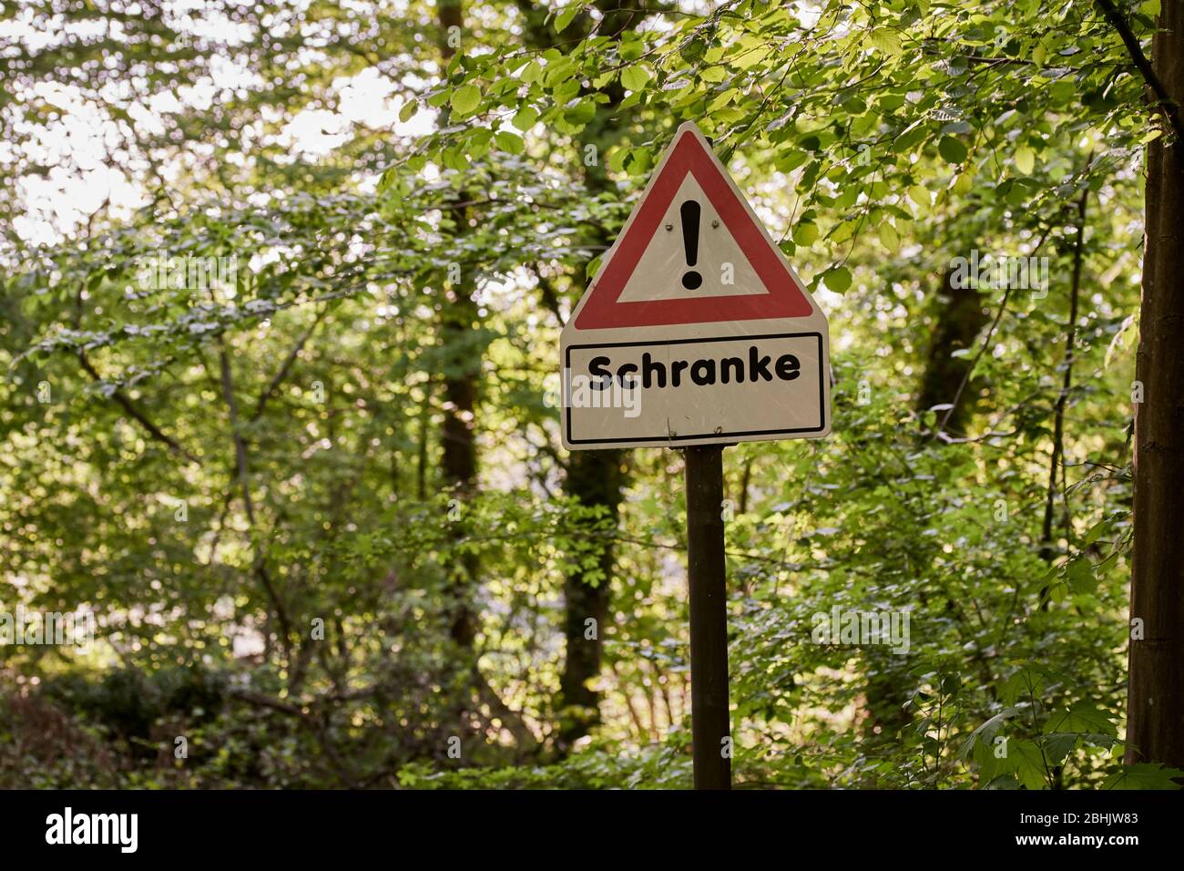 Un panneau d'avertissement rouge et blanc pour une porte de passage de chemin de fer dans la forêt, le printemps ensoleillé Banque D'Images