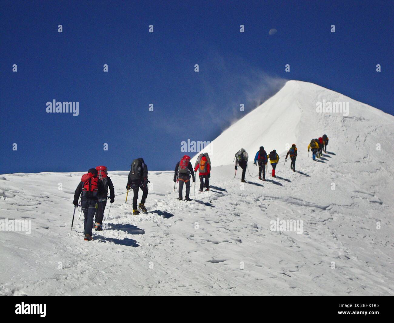 L'équipe de Climbjng monte sur une pente enneigée du pic de Parrot dans le Massif de Monte Rosa, Alpes, Italie Banque D'Images
