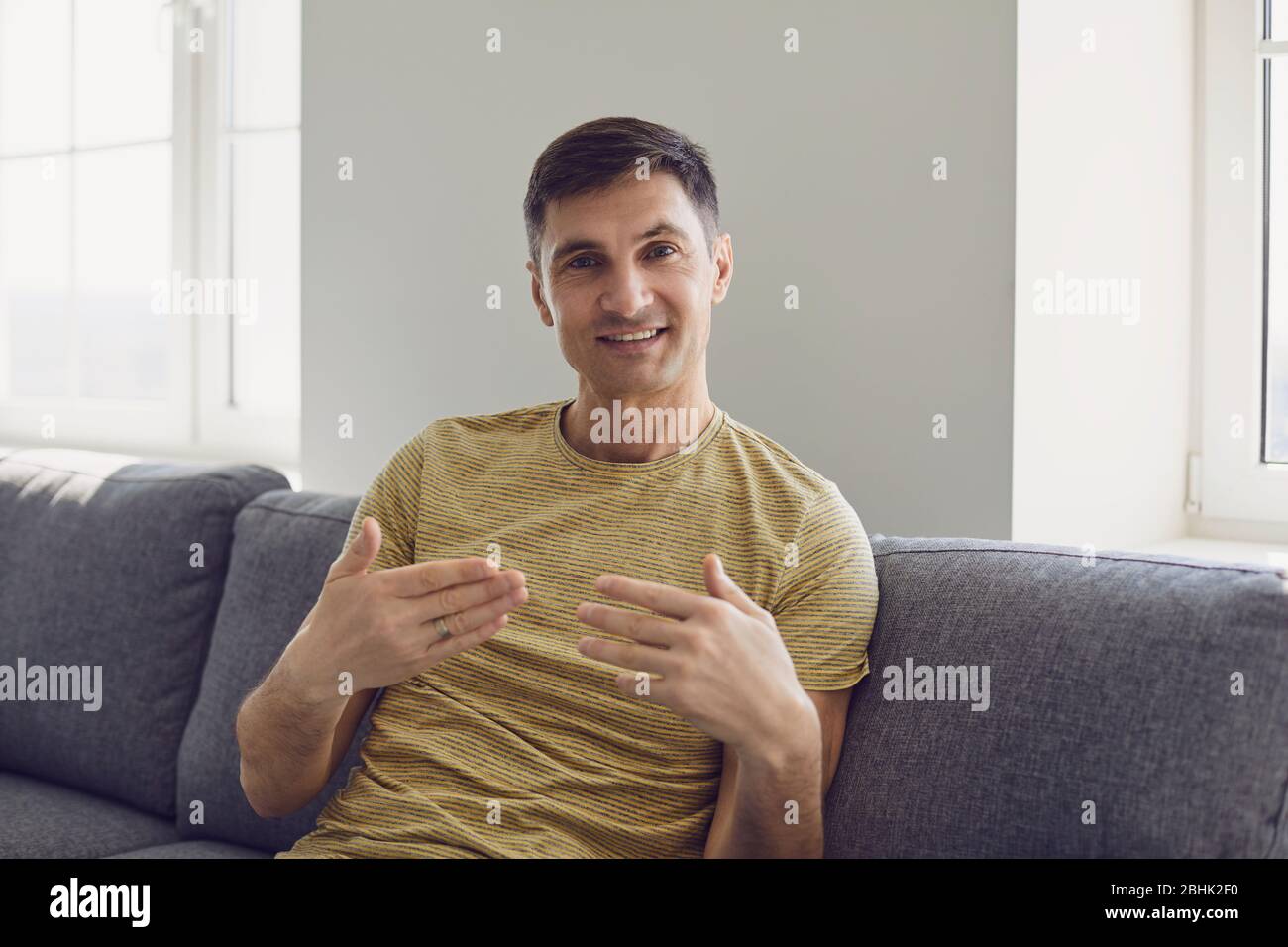 Femme d'affaires dans un t-shirt décontracté souriant regardant l'appareil photo à la maison au bureau Banque D'Images