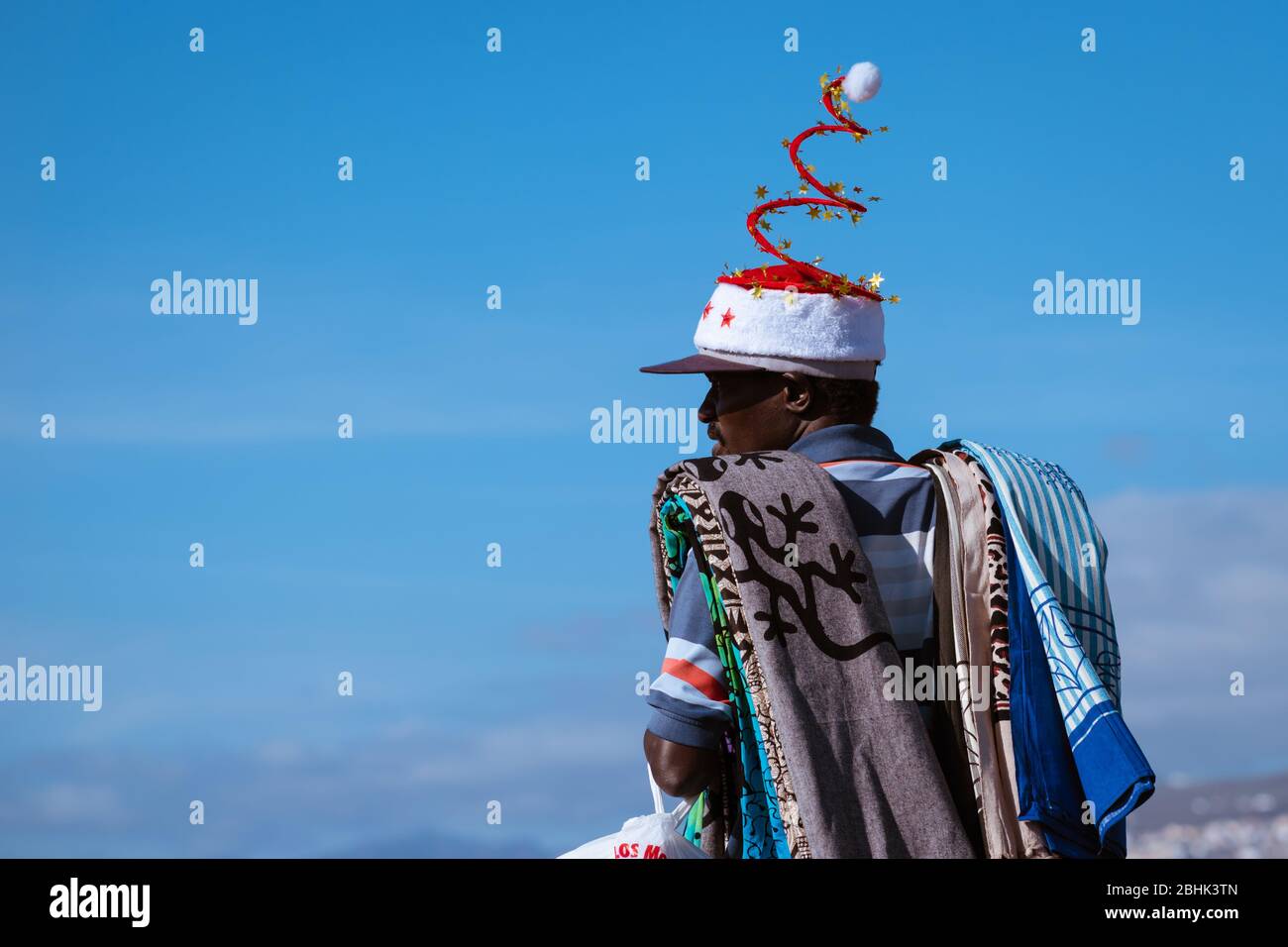 Un vendeur de plage avec des produits de Noël et chapeau se vend aux touristes au soleil d'hiver à Tenerife Banque D'Images