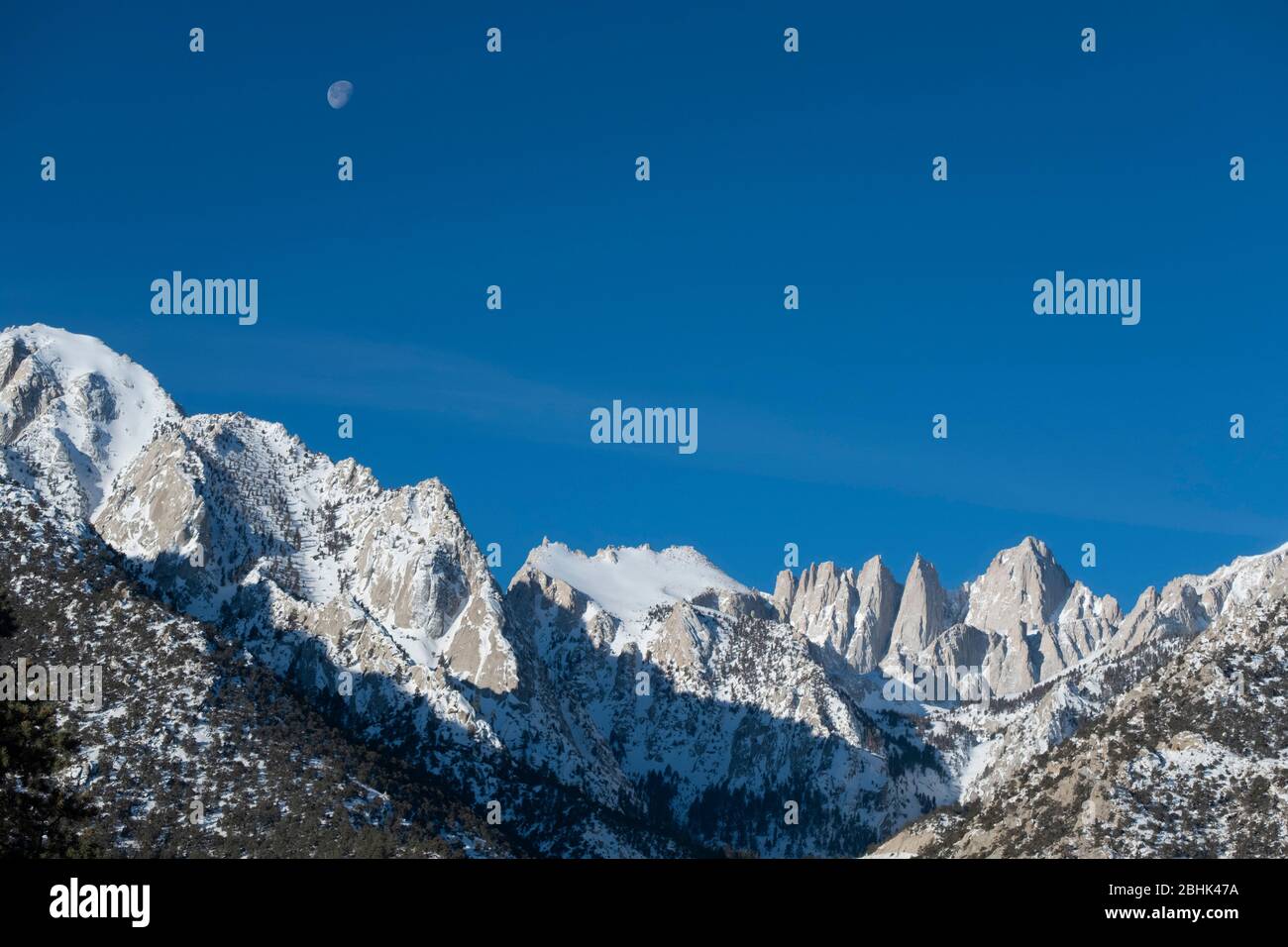 Vue du matin sur le Mont. Whitney et les montagnes de la Sierra Nevada avec une demi-lune contre un ciel bleu Banque D'Images Vue du matin sur le Mont. Whitney et les montagnes de la Sierra Nevada avec une demi-lune contre un ciel bleu Banque D'Images