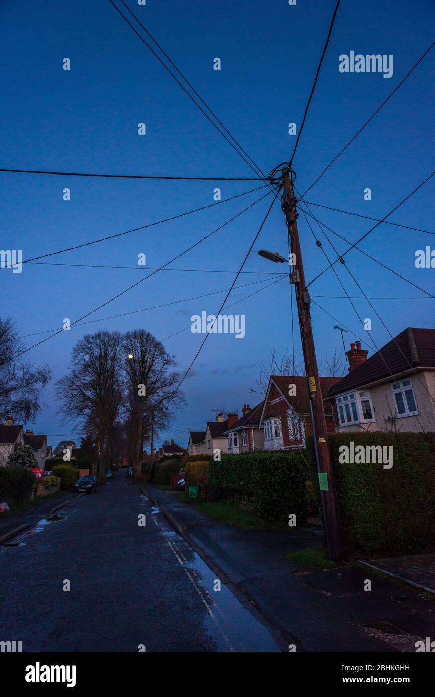 Câbles téléphoniques s'étendant vers les maisons à partir d'un poteau de télégraphe Banque D'Images