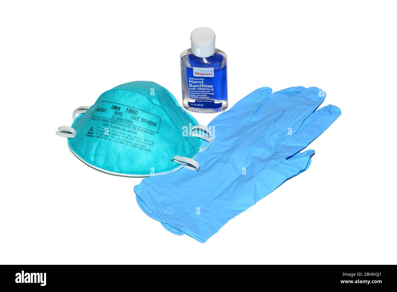 Un flacon de désinfectant pour les mains, un masque respiratoire N95 chirurgical et des gants jetables en nitrile isolés sur un fond blanc. Image découpée. Banque D'Images