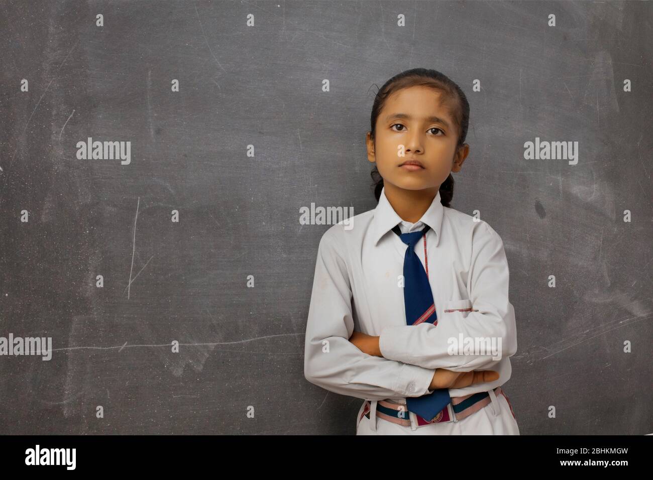 étudiant debout avec tableau de surveillance à l'école Banque D'Images
