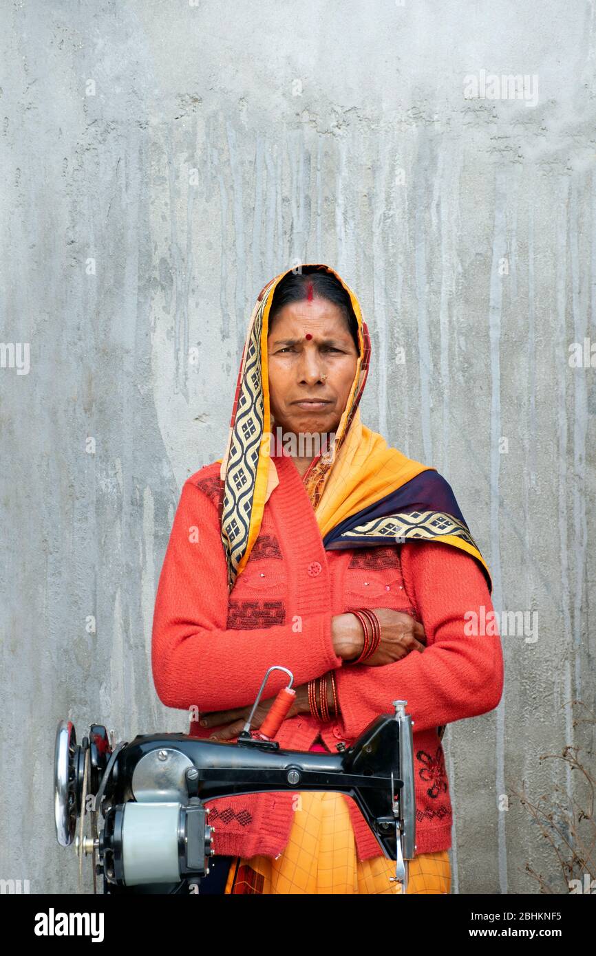 Femme confiante debout avec machine à coudre dans les régions rurales de l'Inde Banque D'Images