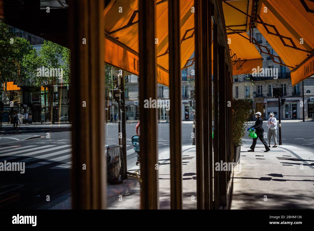 Paris, France. 26 avril 2020. Les personnes portant des masques de visage marchent devant un restaurant fermé à Paris, en France, le 26 avril 2020. La France a vu la mortalité de COVID-19 augmenter de 242 à 22 856 dimanche, la plus faible augmentation quotidienne de cette semaine, apportant des secours au système de santé du pays qui prévoit de lever le verrouillage le 11 mai, ont montré les données du Ministère de la Santé. Crédit: Aurelien Morissard/Xinhua/Alay Live News Banque D'Images