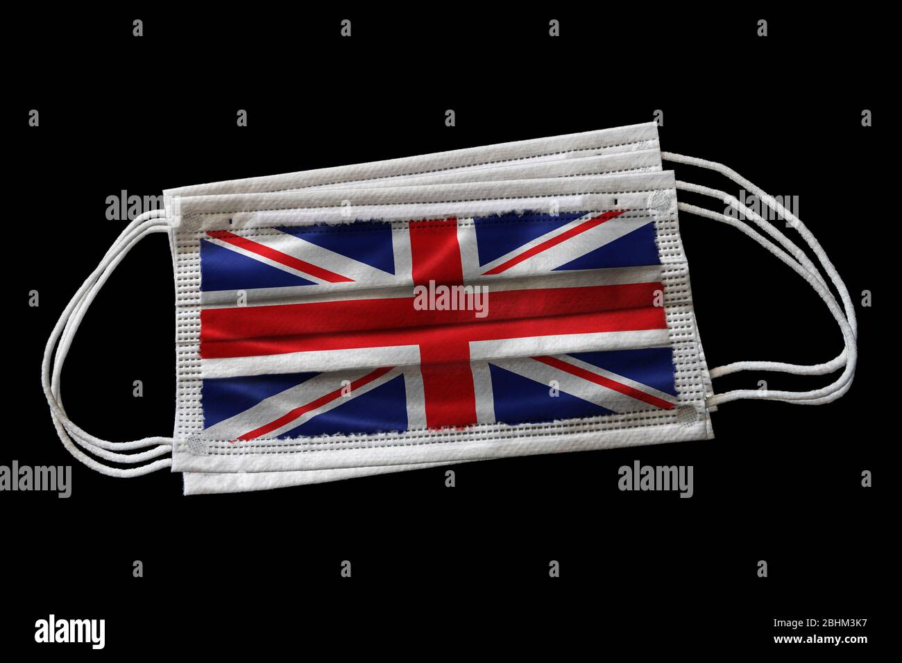 Masques chirurgicaux multiples avec drapeau britannique imprimé. Isolé sur fond noir. Concept d'utilisation de masques de visage dans l'effort britannique de lutte contre Covid-19 c Banque D'Images Masques chirurgicaux multiples avec drapeau britannique imprimé. Isolé sur fond noir. Concept d'utilisation de masques de visage dans l'effort britannique de lutte contre Covid-19 c Banque D'Images