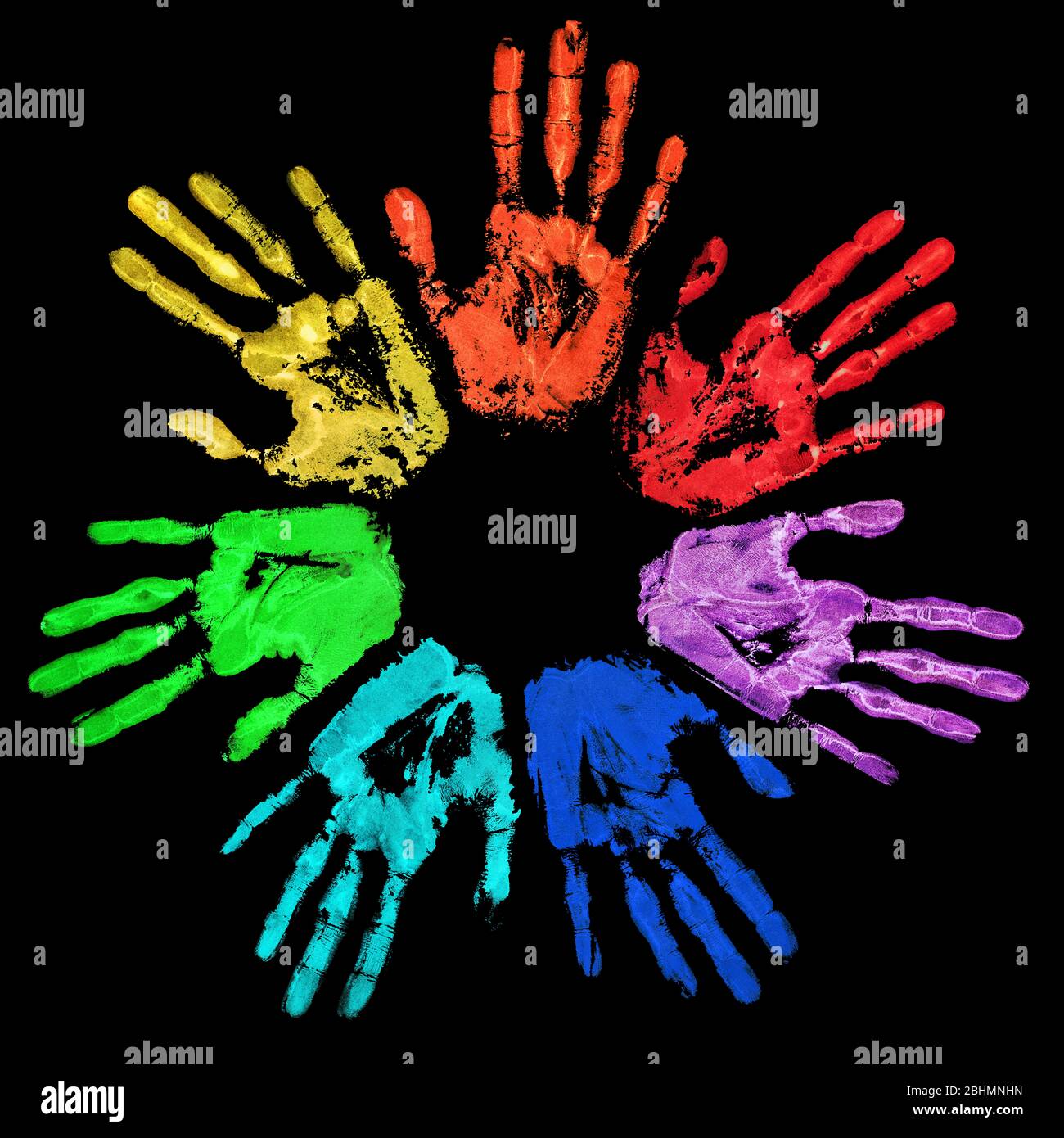 Les mains en couleur arc-en-ciel sont imprimées en cercle sur fond noir, avec une image imprimée colorée à la main aquarelle, une silhouette de main humaine peinte Banque D'Images
