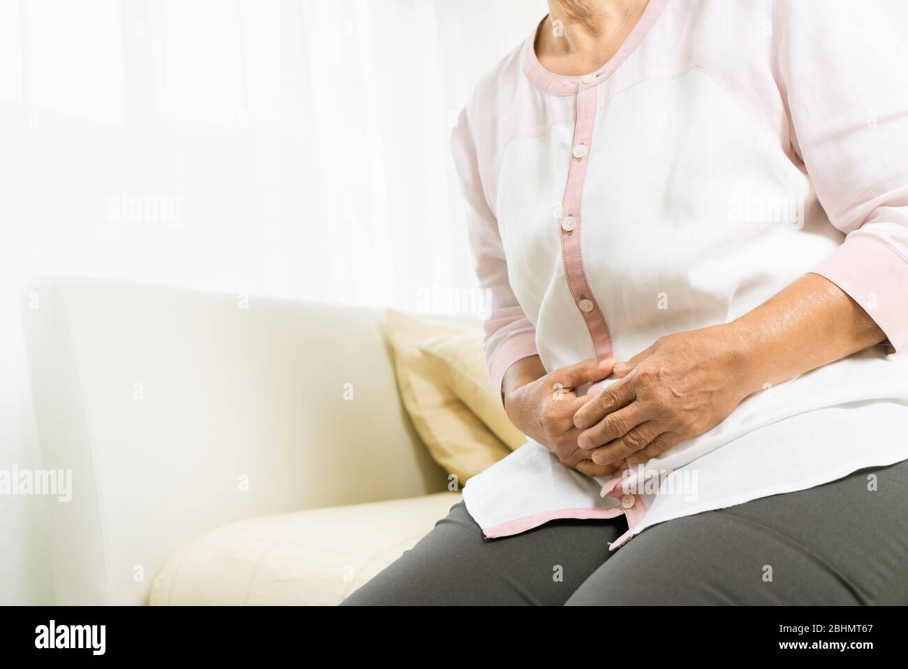 douleur d'estomac de la vieille femme à la maison, problème de santé de concept senior Banque D'Images