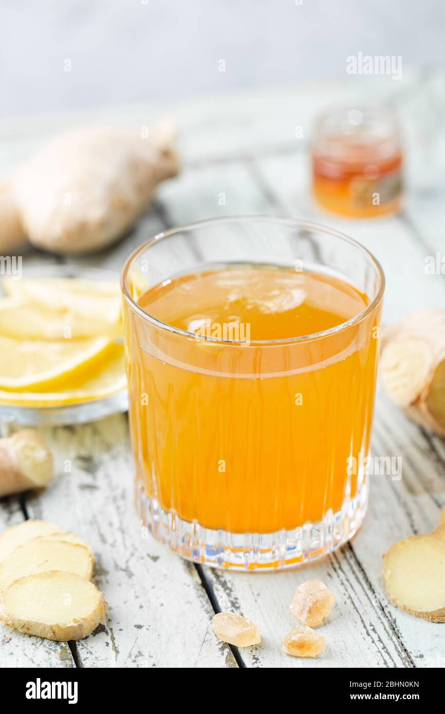 Boisson jaune au gingembre, au citron et à la glace dans un verre, limonade au gingembre maison rafraîchissante ou ALE sur fond blanc Banque D'Images