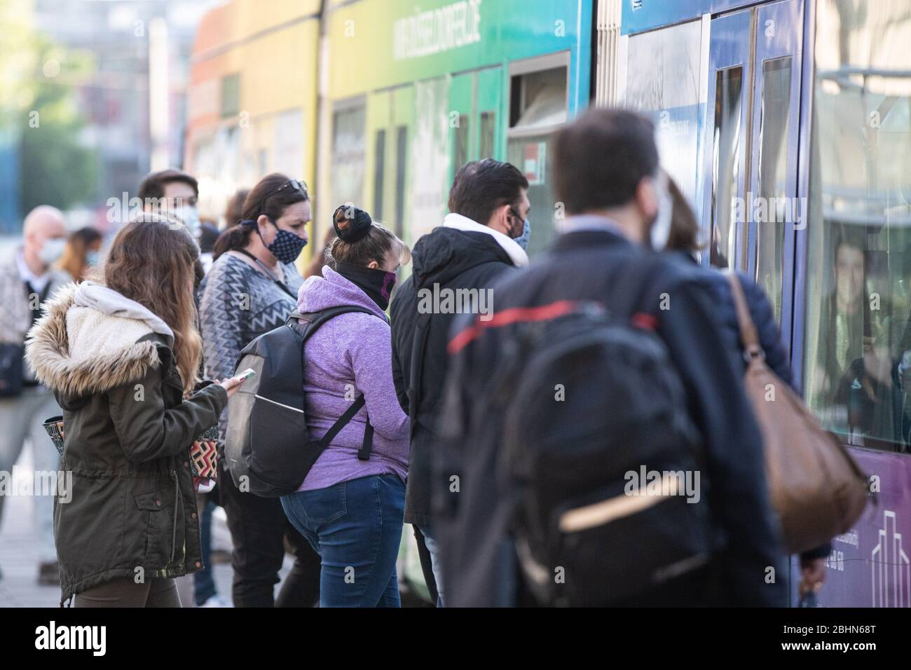 Düsseldorf, Allemagne. 27 avril 2020. De nombreux navetteurs attendent devant un tram le matin avec différents revêtements de visage. À partir de ce lundi, les masques seront obligatoires sur les autobus et les trains et lors des achats en Rhénanie-du-Nord-Westphalie. Les adultes et les enfants de plus de six ans doivent couvrir leur bouche et leur nez - ceux qui n'ont pas de masque professionnel peuvent également utiliser un foulard ou un châle au début. Crédit: Marcel Kusch/dpa/Alay Live News Banque D'Images