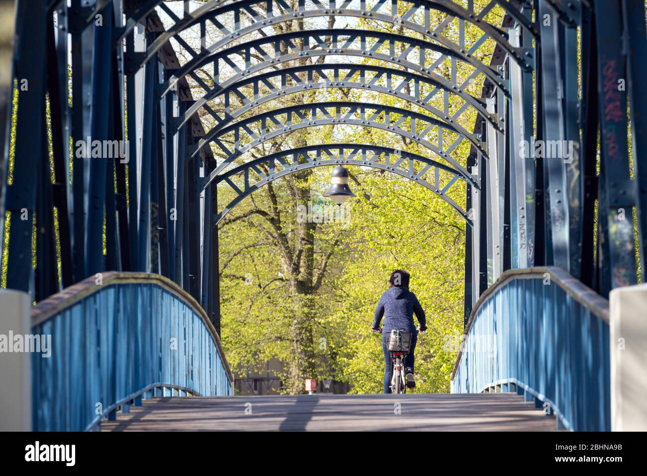 Oranienburg, Allemagne. 24 avril 2020. Une cycliste femelle passe sur le pont Louise-Henriette-Steg au-dessus de Havel. Le pont en acier est considéré comme la plus courte connexion entre la gare et la vieille ville. Construit en 1895 comme un pont en bois, la construction a été donnée le nom de 'schwindsuchtbrücke' (pont de retrait) en raison de sa montée. Le bâtiment est sous une protection monumentale. Crédit: Soeren Stache/dpa-Zentralbild/ZB/dpa/Alay Live News Banque D'Images