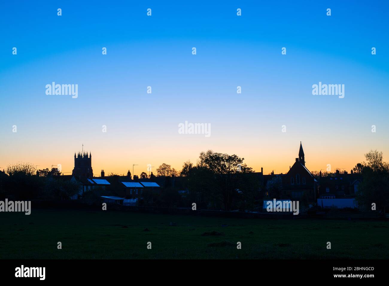 Tour de l'église St Pierre et St Paul et maisons à l'aube à Deddington, Oxfordshire, Angleterre. Silhouette Banque D'Images