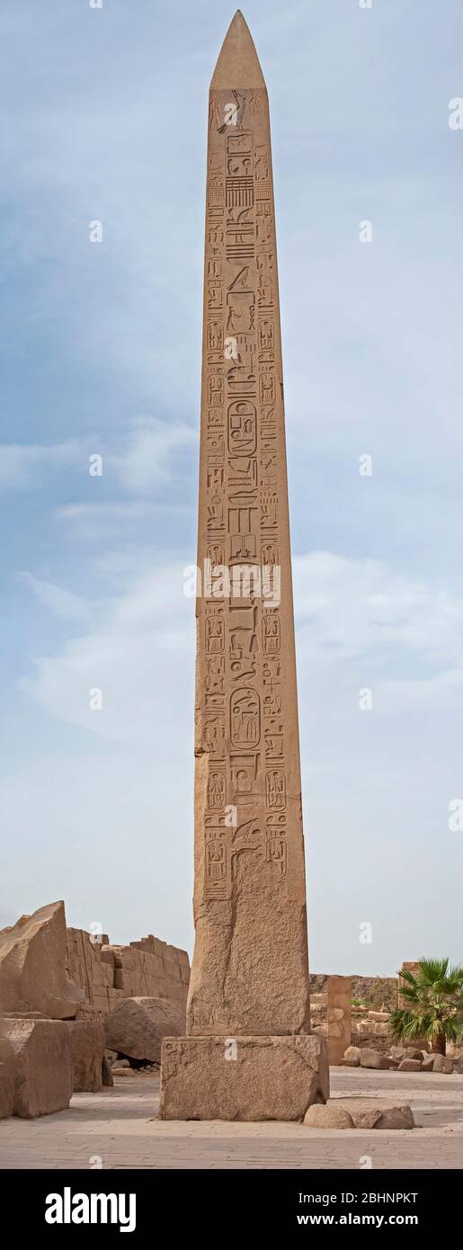 Grand grand obélisque égyptien antique au temple de Karnak à Louxor avec sculptures hiéroglyphiques sur fond de ciel bleu Banque D'Images