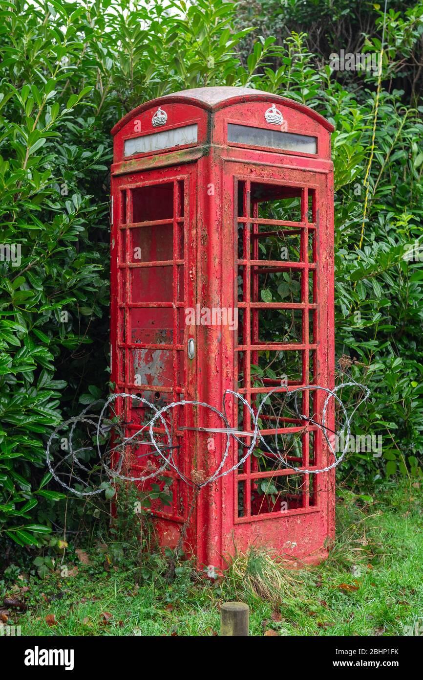 Répertoire rouge anglais traditionnel, délabré et entouré de fil de rasoir Banque D'Images