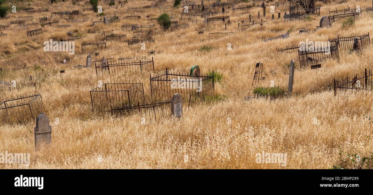 Osh, Kirghizstan - JUne29, 2019: Le cimetière avec des tombes sur la pente d'une colline dans le village d'Osh, Kirghizstan. Banque D'Images