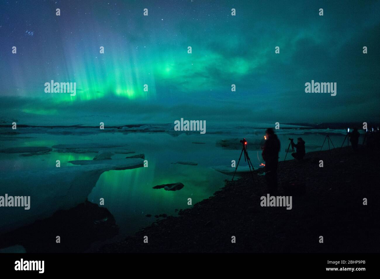 Photographes photographiant l'Aurora Borealis au lac glaciaire de Jökulsárlón, Islande Banque D'Images