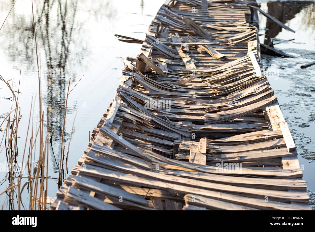 Vieux pont en bois déimpose fait de palettes sur la rivière. Banque D'Images