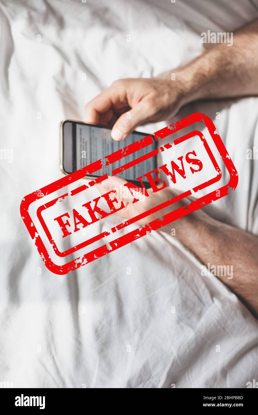 Fausses nouvelles infodemics pendant le concept de pandémie de Covid-19. Les mains de l'homme tenant le téléphone mobile lire les nouvelles mondiales ou le réseau social à la maison. Lire la dernière actualité Banque D'Images