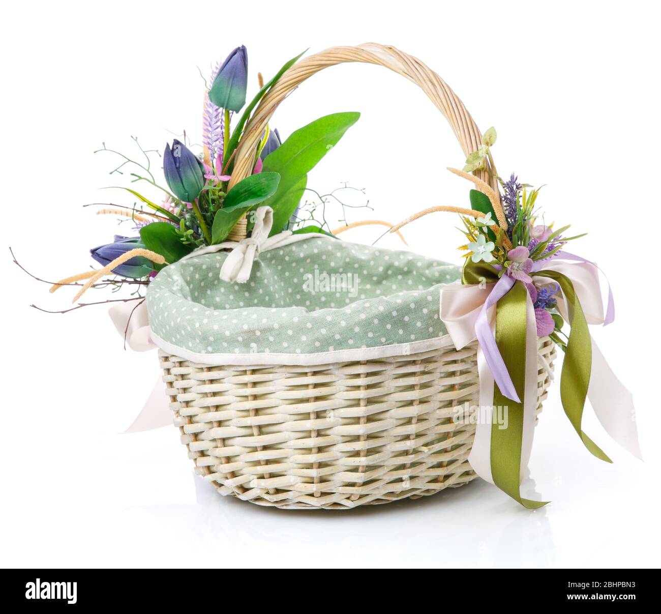 Panier en osier naturel avec fleurs et rubans. Beau noeud sur le côté. Isolé sur un fond blanc Banque D'Images