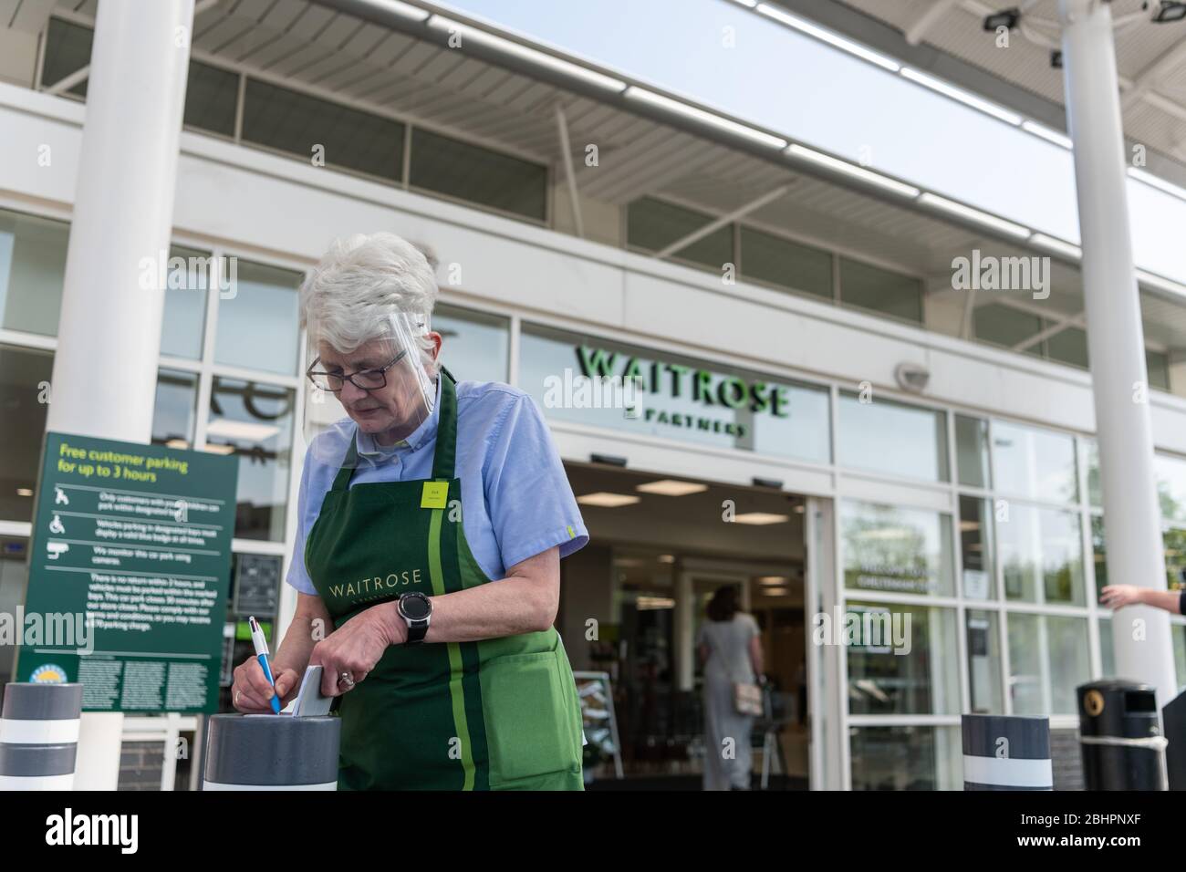 Waitrose & Partners employé porte un bouclier avant à l'extérieur du géant du supermarché. Banque D'Images