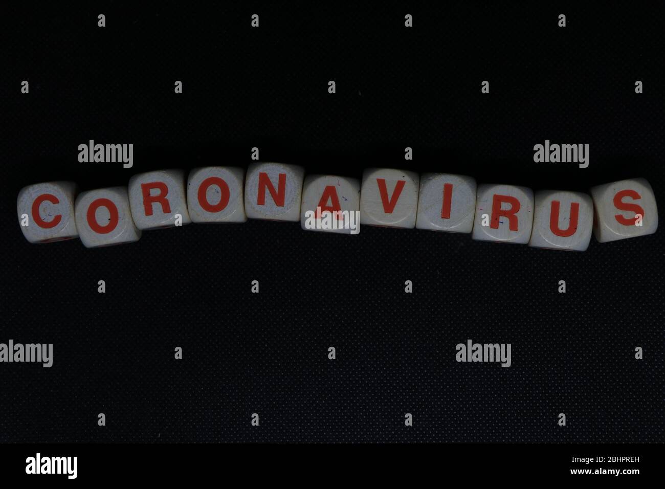 Lettres en bois orange et blanc dés formant l'écriture 'CORONAVIRUS' sur un fond noir. Le virus Corona danger nouvelles. Banque D'Images
