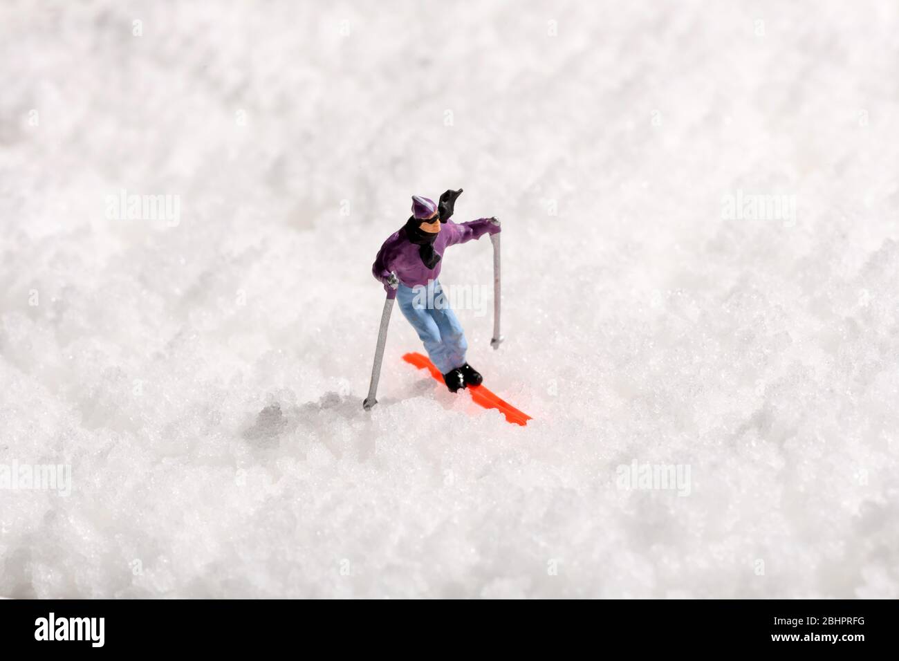Homme miniature seul ski sur neige blanche fraîche d'hiver centrée dans le cadre avec espace de copie dans un concept d'activité ou de voyage d'hiver Banque D'Images