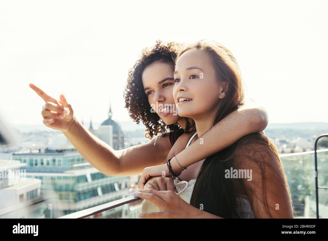 Deux femmes sur un balcon donnant sur Vienne, une avec un bras sur les autres épaules et pointant. Banque D'Images