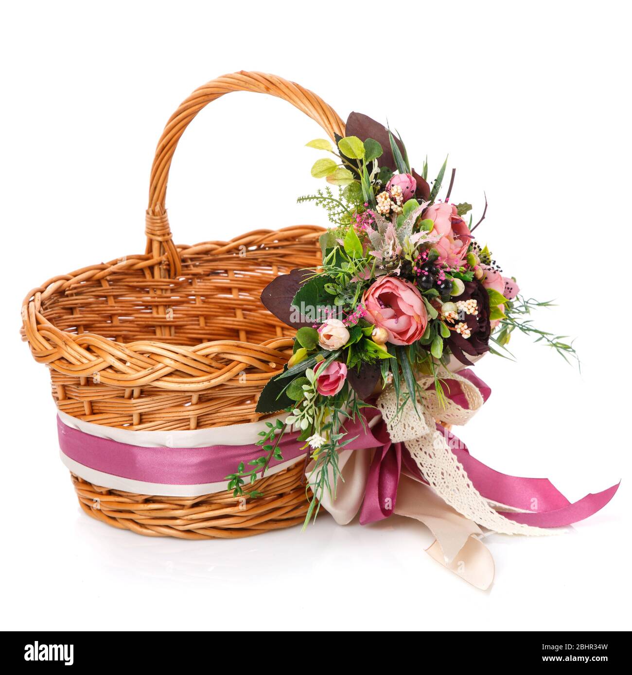Panier en osier naturel avec fleurs et rubans. Magnifique noeud sur le côté. Isolé Banque D'Images